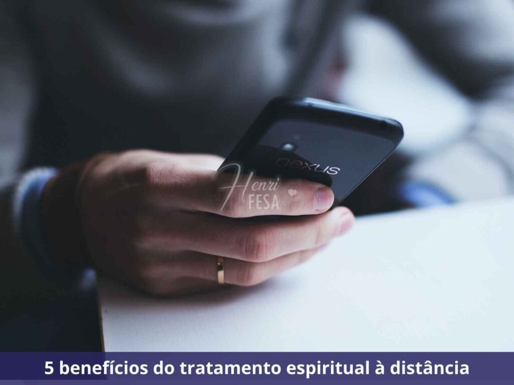Tratamento Espiritual à distância: entenda como funciona Pessoa segurando um celular enquanto recebe tratamento espiritual à distância!
